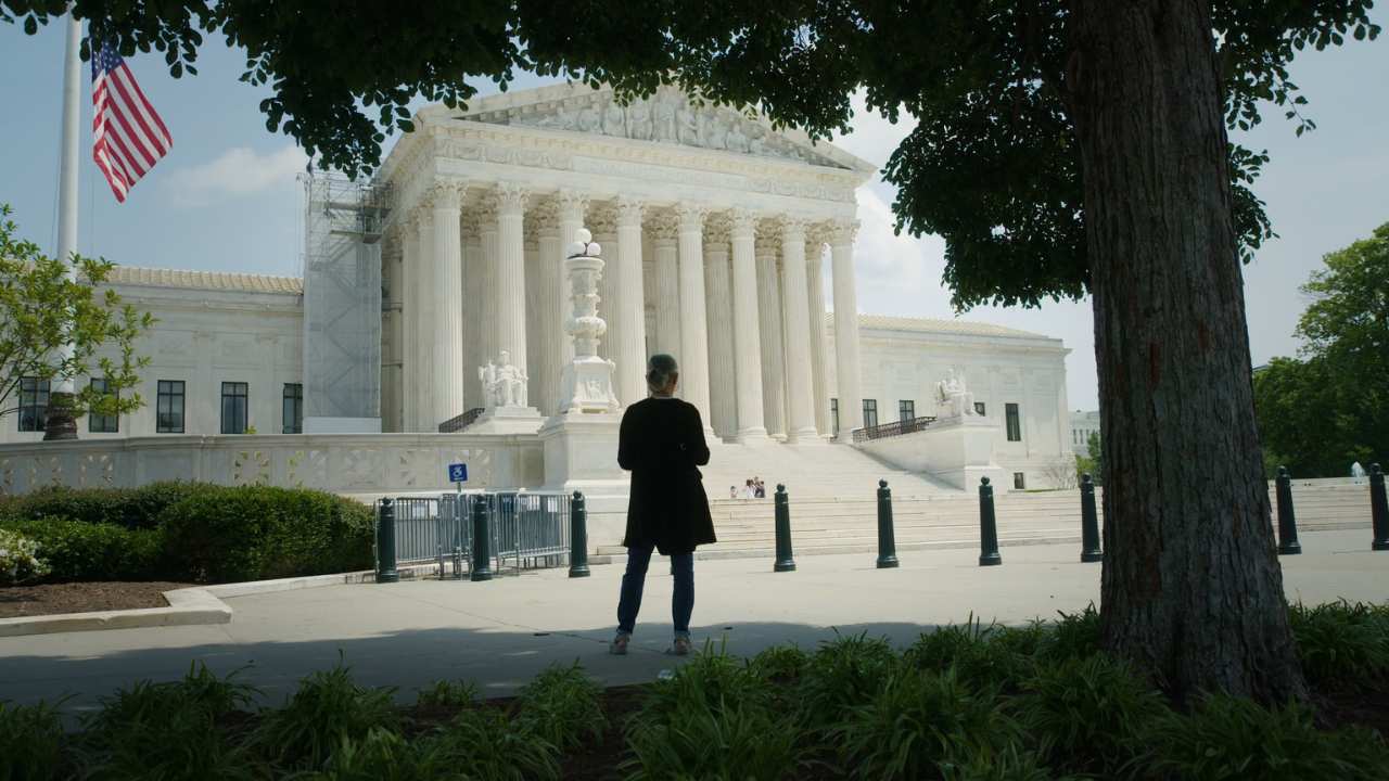 back of a person in front of a white building
